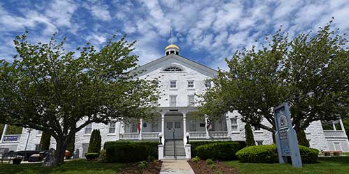 Exterior of the U.S. Naval War College Museum surrounded by trees and historic military architecture in Newport.