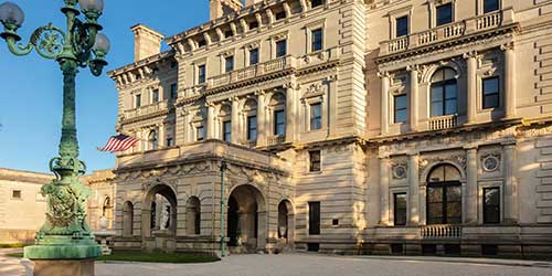 Historic Newport mansion exterior with ornate architecture and landscaped grounds in Rhode Island.